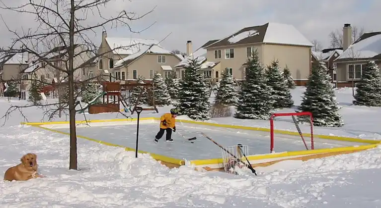 Kid safely enjoying winter at his home's backyard rink